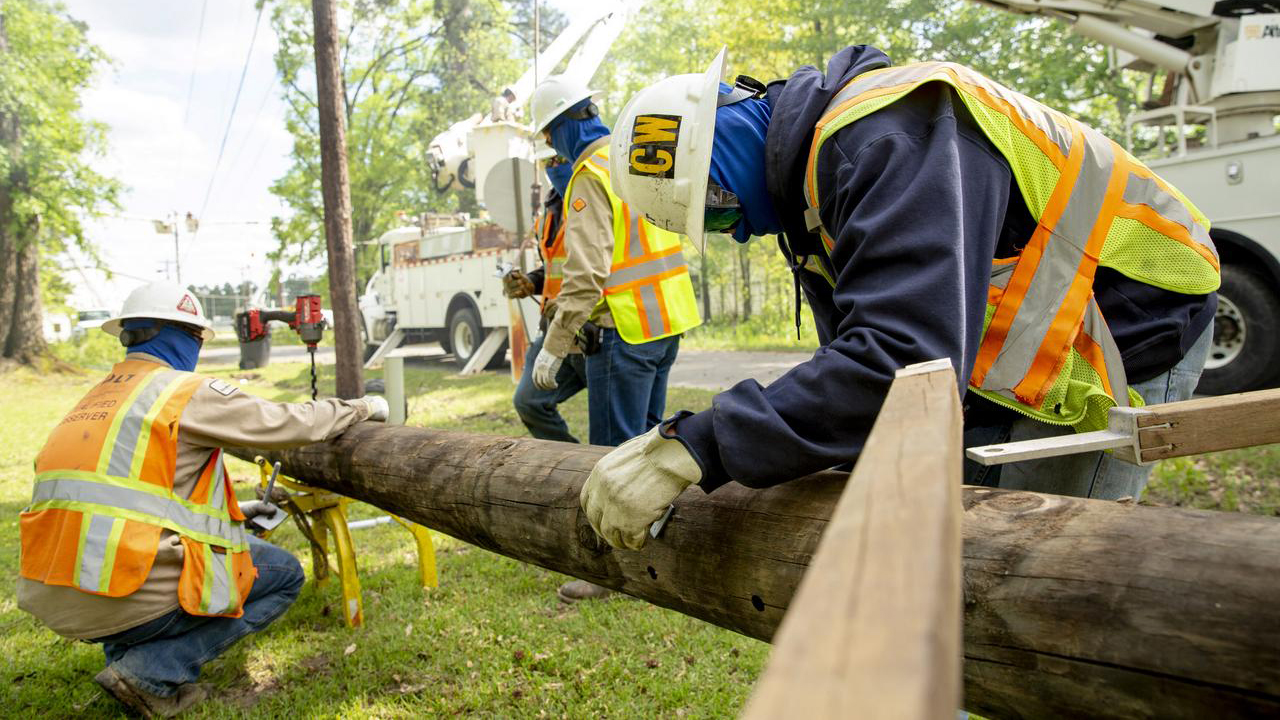 Workers in Smackover prepare one of 775 poles to replace what was broken statewide in the storm. 